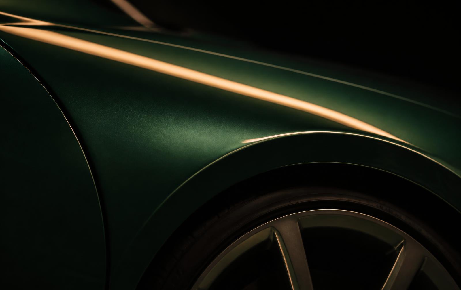 Close detail of a British racing green body panel with a warm reflection